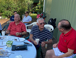 Men gathered around a table outside
