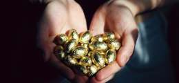 Cupped hands holding golden easter eggs